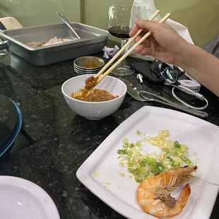 a person holding chopsticks over a plate of food