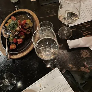 a plate of food and glasses of wine