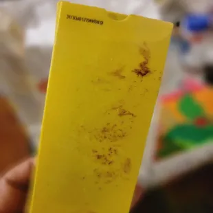 a hand holding a yellow piece of paper