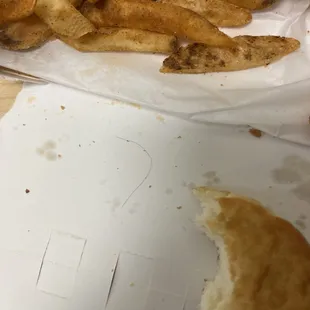 a half eaten sandwich and french fries