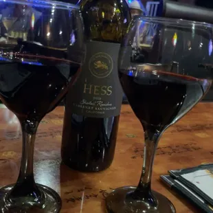 two glasses of wine and a bottle of wine