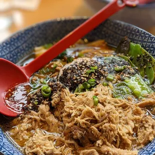 a closeup of a bowl of food with a red spoon