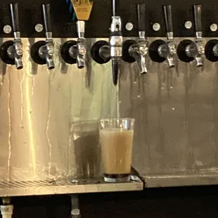 a row of beer taps and a glass of beer