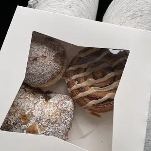 a person holding a box of donuts