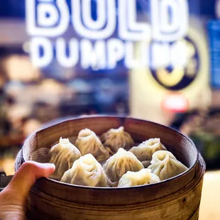 a person holding a bowl of dumplings
