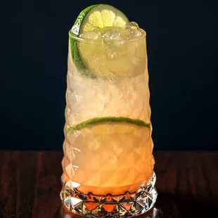 a cocktail with a lime slice on top