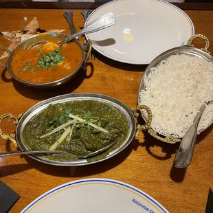 a variety of dishes of food on a wooden table