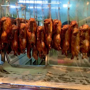 a bunch of chicken hanging from a rack