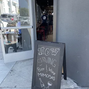 a chalkboard sign on the sidewalk in front of a restaurant
