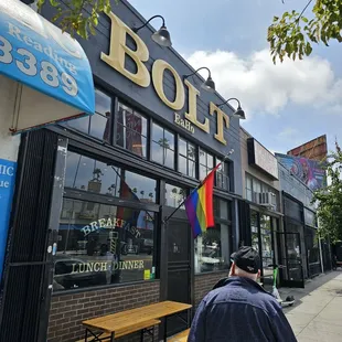 a man walking down a sidewalk in front of a store