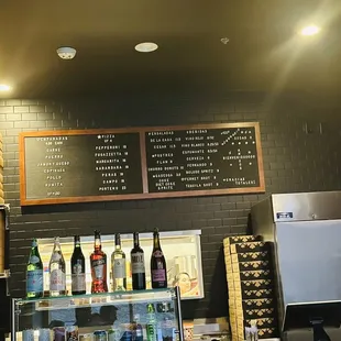a bar counter with a menu and drinks