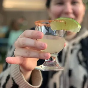 a woman holding a margarita