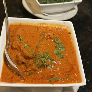 a bowl of curry with a spoon in it