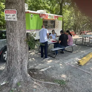 a group of people sitting at a picnic table