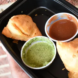 a hand holding a tray of food