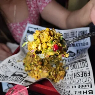 a woman holding a spoon full of food