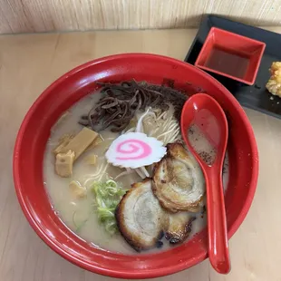  a bowl of ramen with noodles and a spoon