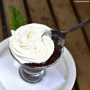 a chocolate dessert with whipped cream and mint leaves