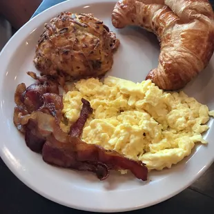 2 eggs, bacon, hash browns and buttery croissant .