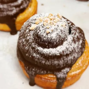 a chocolate covered doughnut with powdered sugar on top