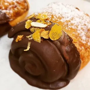 two pastries with chocolate icing and orange peels