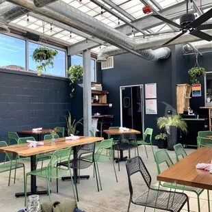 a restaurant with tables and green chairs