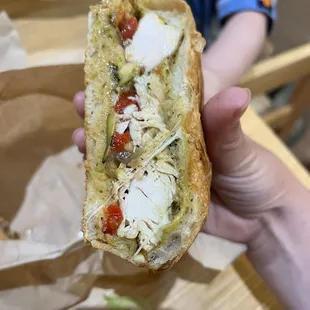 a person holding a sandwich in their hand