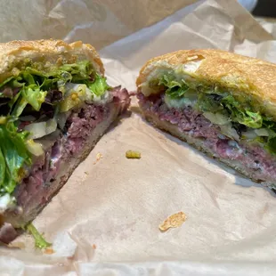 a cut in half sandwich with lettuce and meat