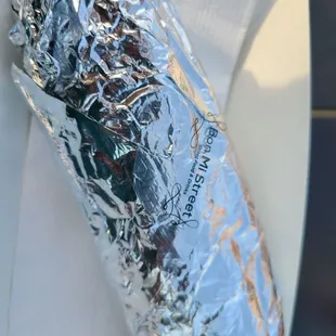 a burrito wrapped in aluminum foil