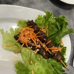 a plate of lettuce with meat and carrots
