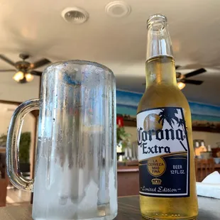 a bottle of corona extra next to a glass of corona extra