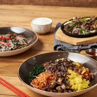 three bowls of food on a wooden table