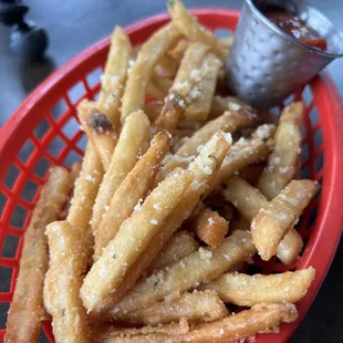 a basket of french fries with dipping sauce