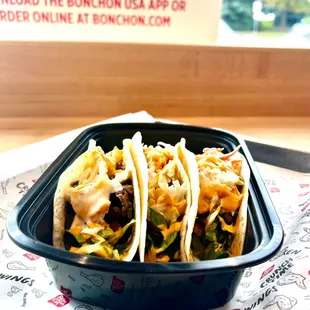 three tacos in a plastic container