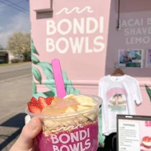 a hand holding a cup of ice cream