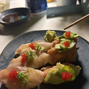 a plate of sushi with chopsticks