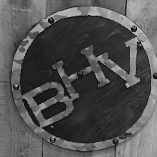 a black and white photograph of a sign on a wooden fence