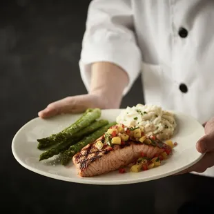 a chef holding a plate of food