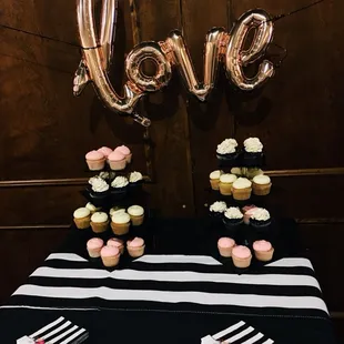 a table with cupcakes and love balloons