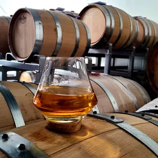 a glass of whiskey on a barrel