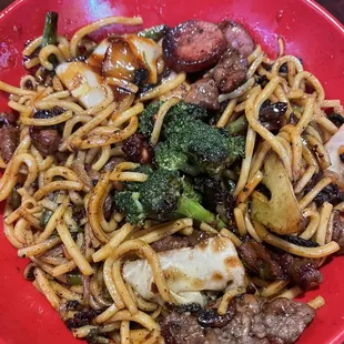 a red plate with noodles and meat