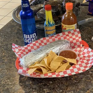 Custom made burrito with seasoned chips and house recipe salsa, and beer