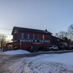 a snowy street with parked cars