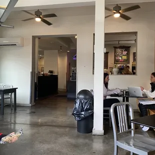 two people sitting at tables in a cafe