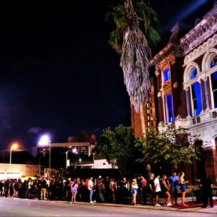 a line of people waiting to cross the street
