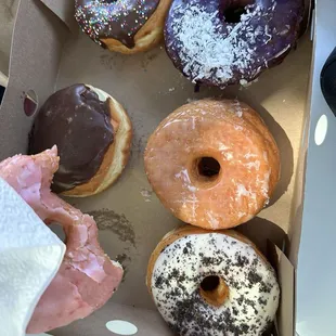 Strawberry, eclair, chocolate with sprinkles, ube with coconut shavings, glaze and Oreo