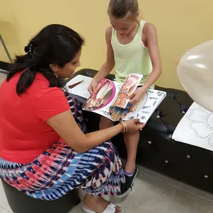 The owner and my daughter picking out henna designs from her catalog.