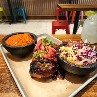 Half roast chicken with coleslaw and rice.