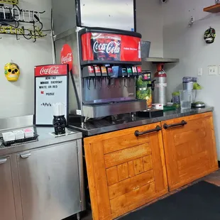 a coca cola machine in a commercial kitchen