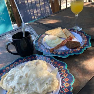 two plates of breakfast food and a glass of orange juice